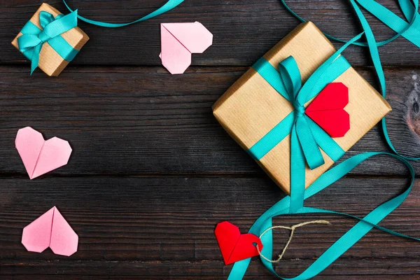 El işi kağıdına sarılmış ve kurdeleyle bağlanmış romantik bir hediye kutusu. Sevdiğin biri için bir hediye. Kalp şeklinde romantik bir not. — Stok fotoğraf