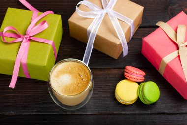 Hediye kutuları, kurabiyeler ve masada bir bardak latte. Şenlikli natürmort.