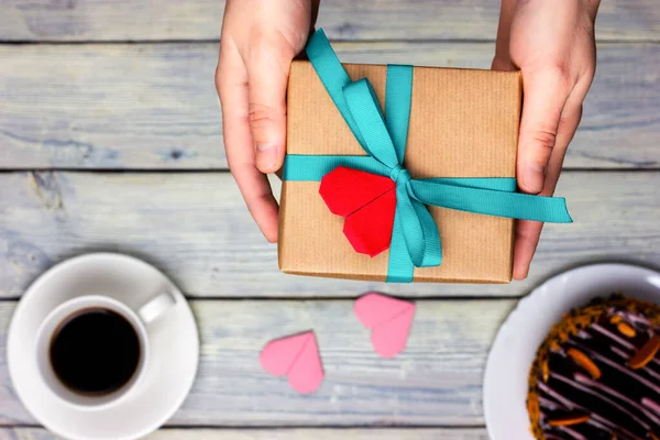 Les mains des femmes tiennent un cadeau de Noël. Cadeau pour la Saint Valentin. Vue d'en haut. Processus de cadeau, félicitations. — Photo