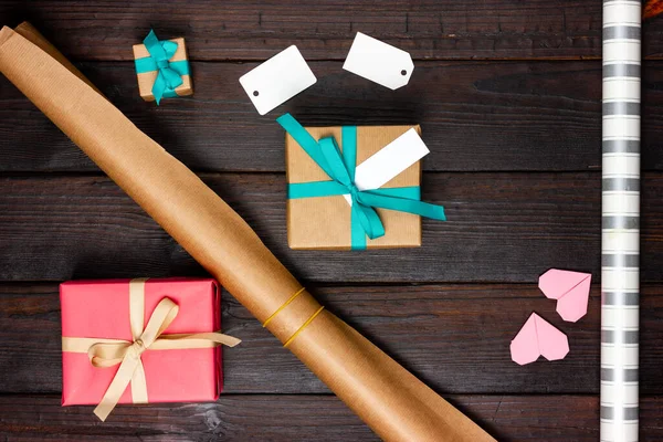 Festive Flat Lay. Processo de embrulho de presentes. Caixas de presente e papel de embrulho na mesa. Vista de cima. — Fotografia de Stock