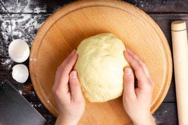 Ekmek hamuru yapma süreci. Kadın eli hamuru tutar. Hamur masanın üzerinde. Düz Yat.