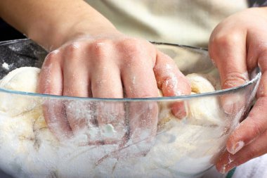 Maya hamuru örüyorum. Kadınların elleri pastayı tutuyor. Kadın ekmek için hamur yoğuruyor. Kırsal biçim.