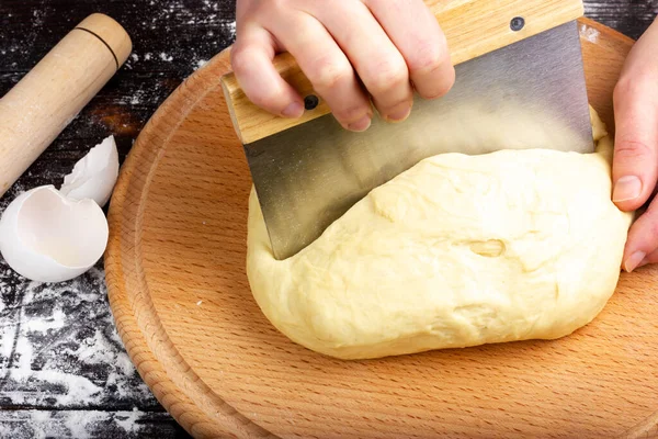 Preparación de la masa. Las manos de las mujeres cortan la masa en trozos. Amasar masa para hornear pan. — Foto de Stock