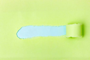 Yırtık kağıt. Bir kağıt parçasında bir delik. Açık yeşil yırtık kağıt yaprak.