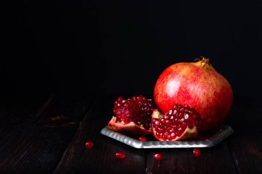 Koyu arkaplanda kırmızı nar meyvesi. Kırsal nar tohumları.