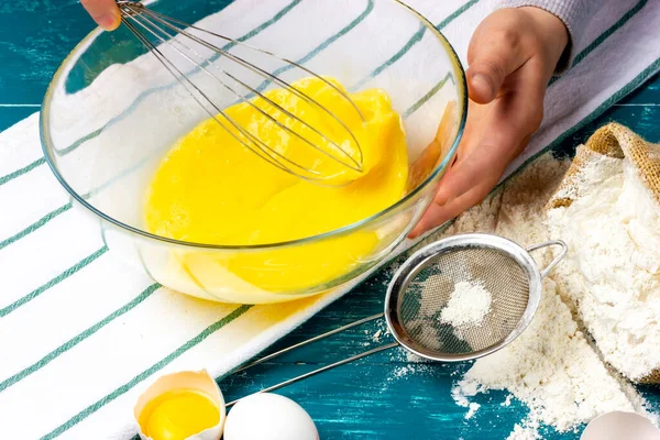 Домогосподарка б'є курячі яйця ручним віслюком. Жінка готує батарею для вафель. Процес приготування тіста . — стокове фото