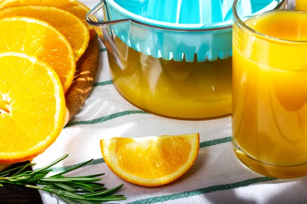 Свежевыжатый апельсиновый сок. Кусок апельсина и стакан апельсинового сока. Солнечный свет. — стоковое фото