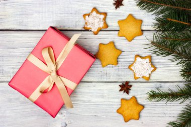 Bej kurdeleli pembe hediye kutusu ve yıldız şeklinde kurabiyeler. Sihirli bir tatil. Noel ruhu.