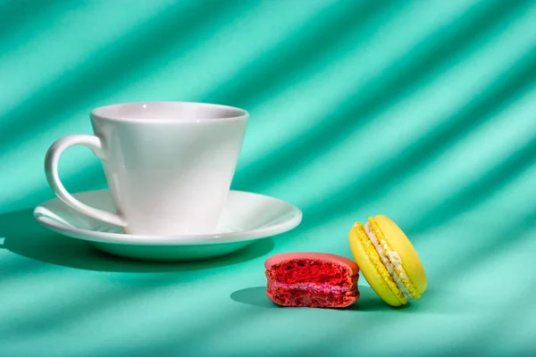 Eine Tasse Kaffee und kleine Mandelmehlkekse. Licht aus dem Fenster. Licht durch Jalousien. — Stockfoto