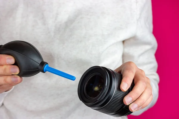 Servicios de equipos fotográficos. El proceso de limpieza del polvo desde una lente fotográfica. — Foto de Stock