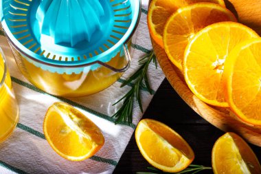 Portakal suyu üretme süreci. Portakal dilimleri ve meyve sıkacağı.
