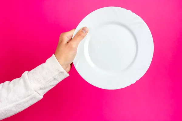 White ceramic plate in a womans hand. Empty ceramic plate.