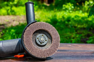 Tahta bir masada öğütücü. Açı öğütücüsünde aşındırıcı tekerlek.