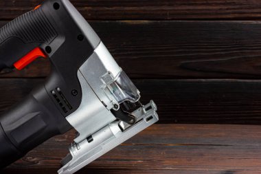 Tahta arka planda elektrikli yapboz. Elektrikli el aletleri. Alçak tuş.