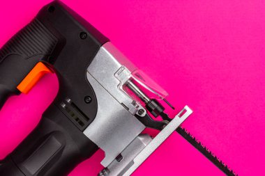 Pembe arka planda elektrikli yapboz. El gücü aracı.