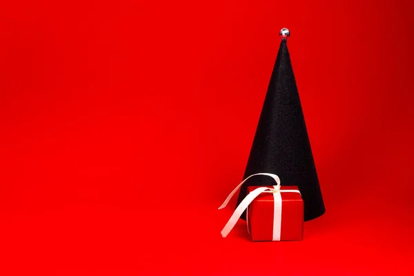 Presente de Natal vermelho com uma fita branca. Árvore de Natal. Presente debaixo da árvore. — Fotografia de Stock