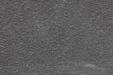 Beton macun dokusu. Duvarda alçı var. Sert granüler yüzey. Yüzey gri..