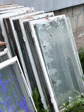 Geri dönüşüm veya yeniden kullanım için çerçeveleri soyulmuş eski pencereler yığını. Yaratıcı ya da profesyonel projeler için harika