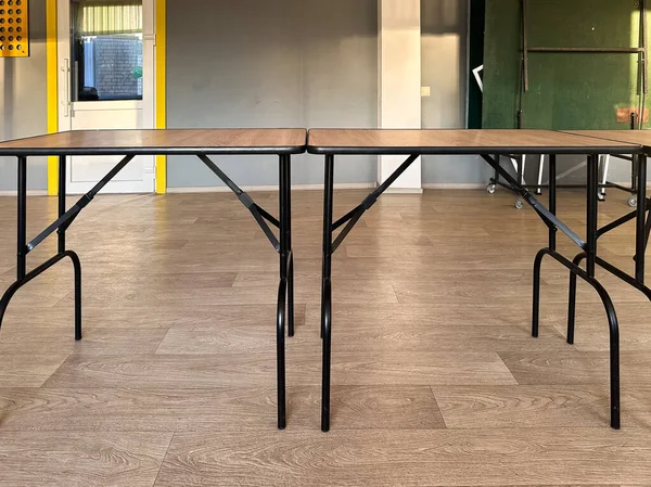 Ahşap döşemeli boş bir odada iki katlanan masa. Çeşitli yaratıcı ihtiyaçlar için uygun