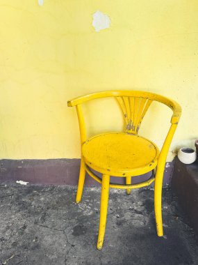Kırsal alanda boyası soyulan klasik sarı koltuk. Yaratıcı ya da profesyonel projeler için harika