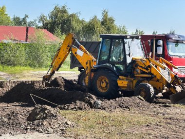 Kazıcı güneşli bir günde inşaat alanında toprak kazıyor. Yaratıcı ya da profesyonel projeler için harika