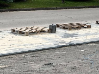 Asfalt kaldırımda ahşap paletler ve inşaat malzemeleri. Yaratıcı ve ticari kullanım için ideal