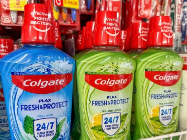 Mağaza rafında Colgate gargara şişeleri, temiz nefes garantili. Çok çeşitli kullanım alanları için uygun