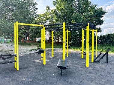 Ağaçları ve açık gökyüzü olan bir parkta açık spor aletleri. Çeşitli yaratıcı ihtiyaçlar için uygun