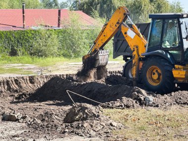 Kazıcı inşaat alanında siper kazıyor. Çok çeşitli kullanım alanları için uygun