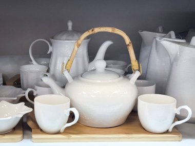 Çaydanlıklı beyaz seramik çay seti ve tahta tepside bardaklar. Çok çeşitli kullanım alanları için uygun