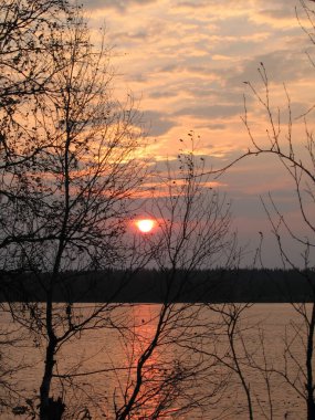 Gölün üzerinde kasvetli bir günbatımı.