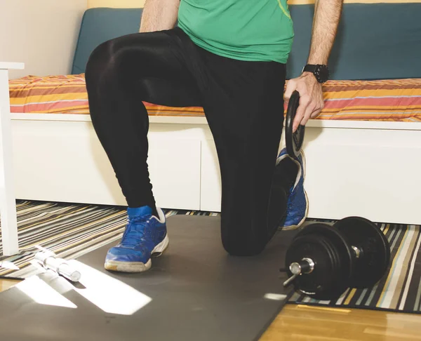 Spor salonundaki antrenman zeminde ağırlık çalışıyor. 