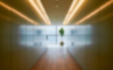 Abstract blurred image of a modern office corridor illuminated by bright ceiling lights in a calm ambience