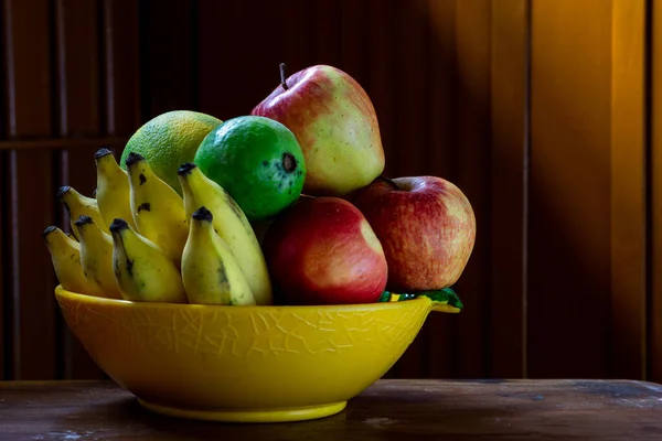 Eine Obstschale Mit Holztisch Und Hintergrund Mit Künstlerischer Beleuchtung — Stockfoto