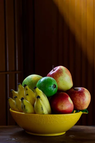 Eine Obstschale Mit Holztisch Und Hintergrund Mit Künstlerischer Beleuchtung — Stockfoto