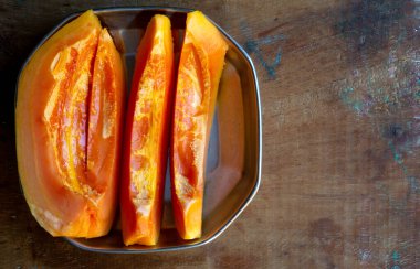 Taze Papaya, tahta bir masanın tepsisinde parçalara ayrılmış.
