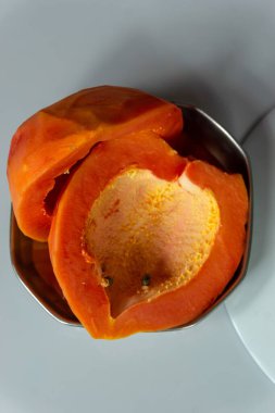 Taze Papaya meyvesi seçici bir odak ile bir tabakta iki parçaya bölünmüş.