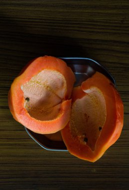 Taze Papaya meyvesi seçici bir odak ile bir tabakta iki parçaya bölünmüş.