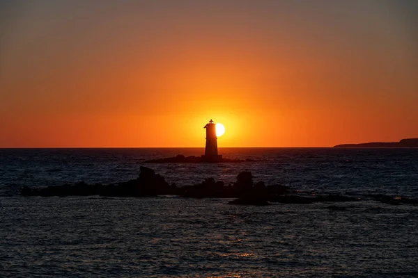Güneş Mangiabarche 'nin Deniz Feneri' nin arkasında batıyor. Carloforte Adası, San Pietro Adası ve Calasetta Sant 'Antioco' nun önünde.