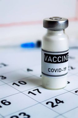 2021 takvimine kadar Coronavirus aşısı konsepti, aşı doz şişesi, beyaz arka plan. Dikey fotoğrafçılık.