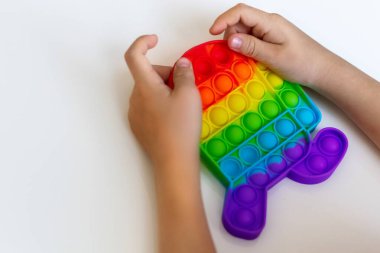 Basit bir balon antistrest oyuncağını iten bir çocuğun elini yakın plan çekimde beyaz arkaplana yerleştir..