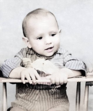 Sevimli bir çocuğun klasik portresi. Çocuk coşkuyla bir şeye bakıyor. Retro fotoğraf, 1960.