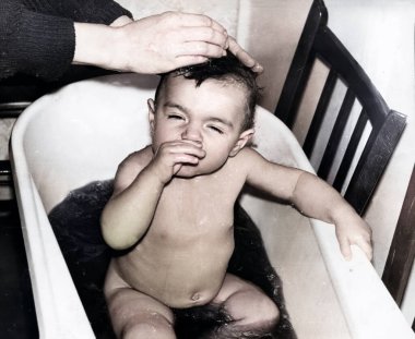 Havuzda banyo yapan küçük bir kızın klasik portresi. Kız iplik ve papatya çayı gibi şifalı bitkilerle yıkanmış. 1995 'ten kalma eski bir fotoğraf.