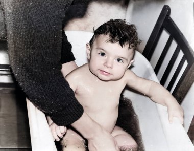 Havuzda banyo yapan küçük bir kızın klasik portresi. Kız iplik ve papatya çayı gibi şifalı bitkilerle yıkanmış. 1995 'ten kalma eski bir fotoğraf.