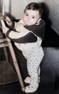 Yürümeyi öğrenen küçük tatlı bir kızın klasik portresi. 1995 'ten kalma eski bir fotoğraf.