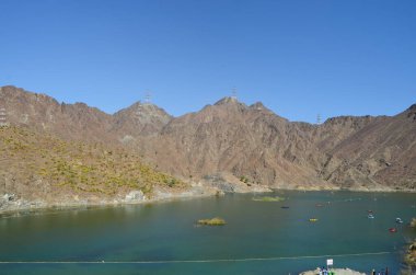 A beautiful view of Al Rafisah dam, a lake surroundings by rocky mountain, Khorfakkan, United Arab Emirates.