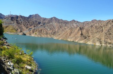 A beautiful view of Al Rafisah dam, a lake surroundings by rocky mountain, Khorfakkan, United Arab Emirates.