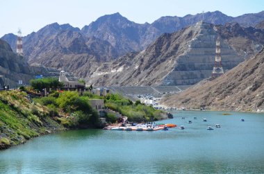 A beautiful view of Al Rafisah dam, a lake surroundings by rocky mountain, Khorfakkan, United Arab Emirates.