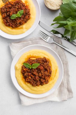 Haşlanmış mısır unu ya da et soslu polenta. Paçavra alla bolonez. Beyaz arkaplan, dikey resim.