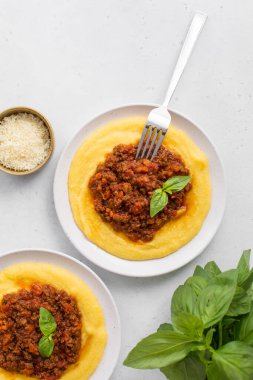 Haşlanmış mısır unu ya da et soslu polenta. Paçavra alla bolonez. Beyaz arka plan. Dikey resim.